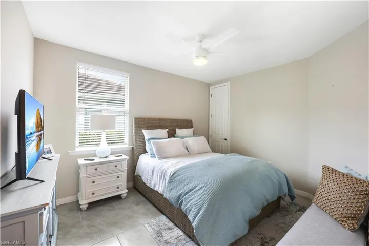 Bedroom featuring light tile patterned floors and ceiling fan