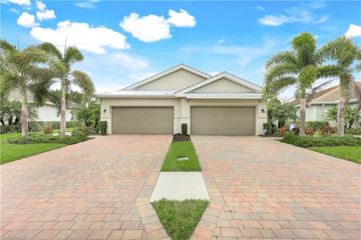 Ranch-style home with board and batten siding and decorative driveway