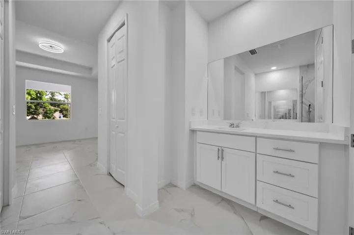 Bathroom featuring light marble finish floors and vanity