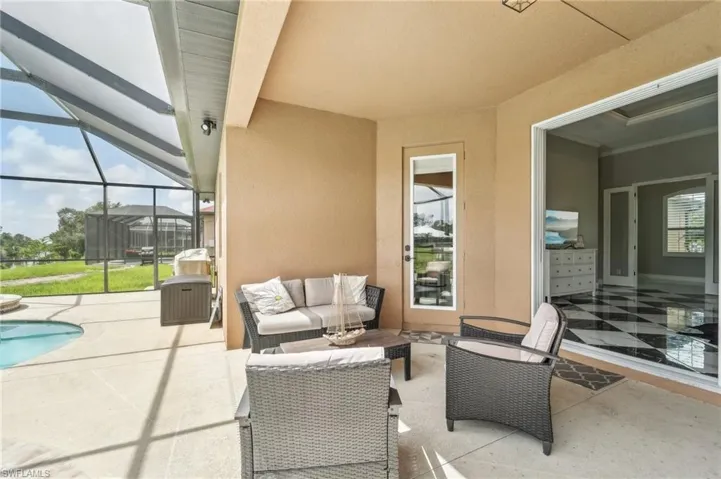 Screened patio with a covered section, an inground pool, and direct access to an interior room with checkerboard tile flooring