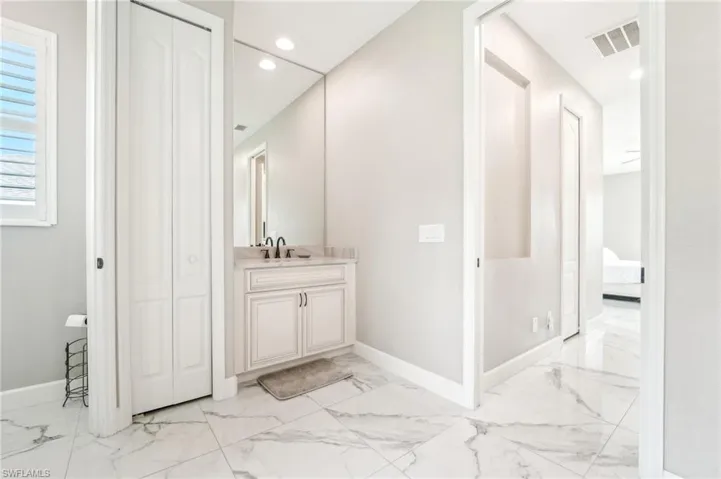 Bathroom vanity featuring a light-colored countertop with an undermount sink and dark fixtures