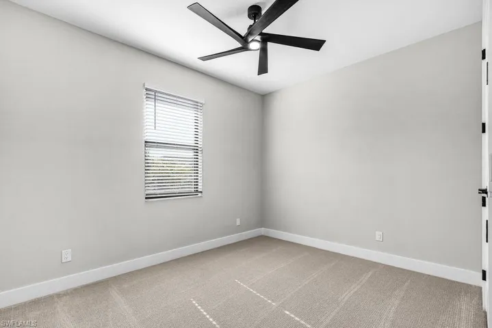 Spare room with light carpet and a ceiling fan