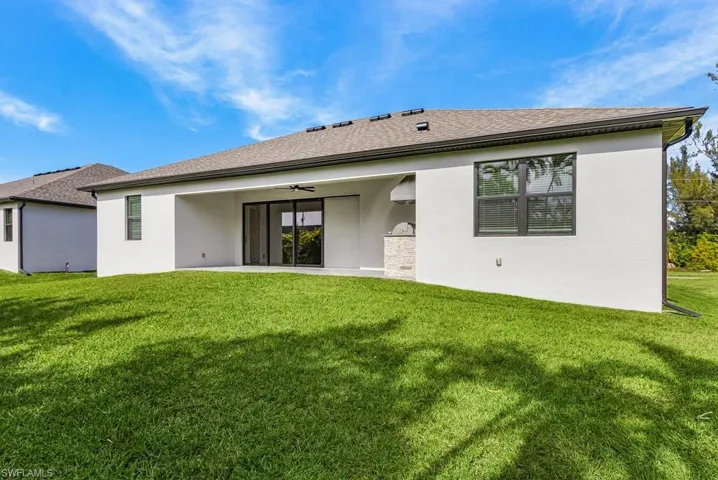 Back of house with a ceiling fan, a patio area, and stucco siding