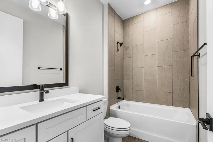 Bathroom featuring bathtub / shower combination, vanity, and recessed lighting