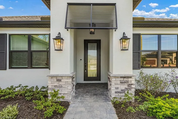 Property entrance with stone siding and stucco siding