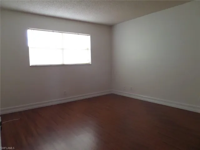 Spare room with dark wood finished floors and a textured ceiling