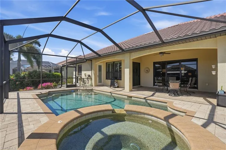 Relaxing pool / spa with a patio, a sunroom, and a lanai