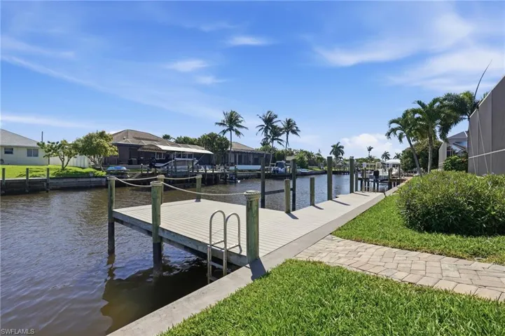 Dock featuring a water view, a residential view, and a lawn