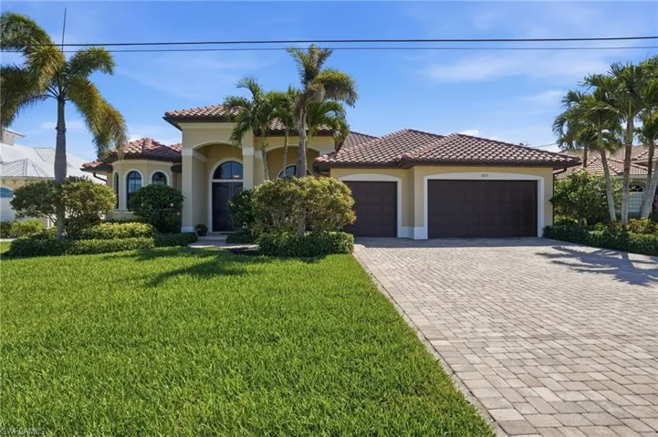 Mediterranean / spanish house with decorative driveway, an attached garage, stucco siding, and a front yard