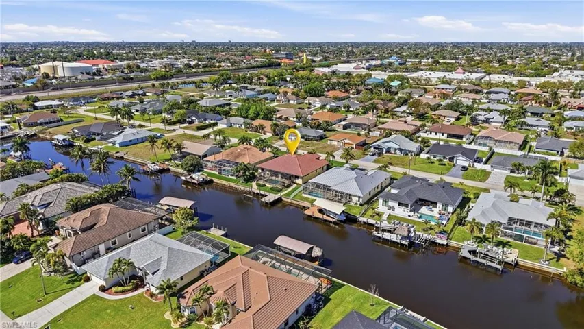 Aerial view of property and surrounding area featuring a large body of water and nearby suburban area