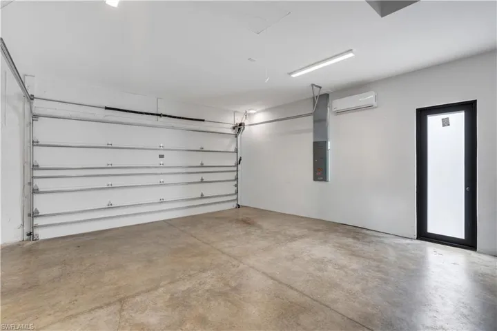 Garage featuring electric panel and a mini split for heating / cooling