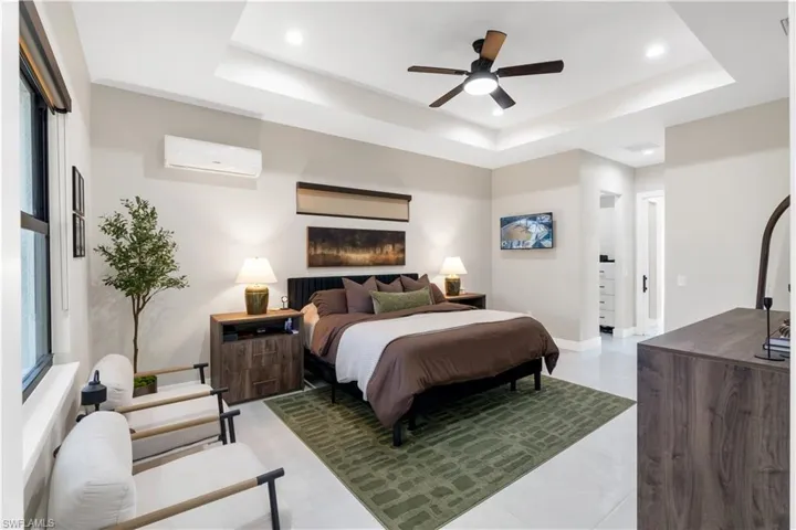 Bedroom featuring a wall mounted mini split, ceiling fan, and recessed lighting