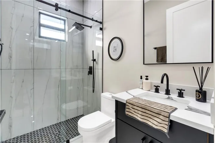 Full bathroom featuring vanity and a marble finish shower