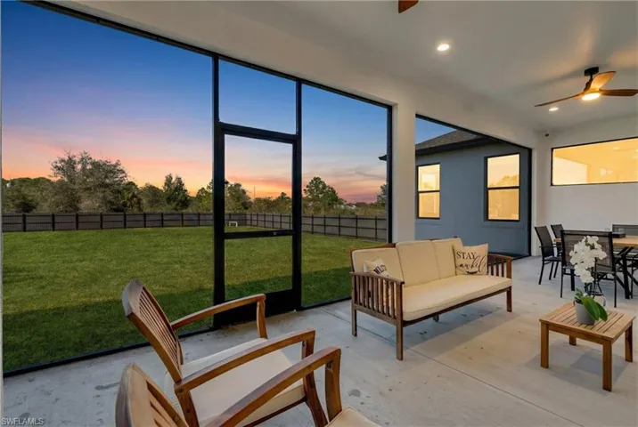 Sunroom / solarium with a ceiling fan, outdoor lounge area, and a patio