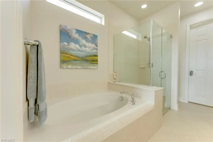 Bathroom featuring tile patterned flooring and plus walk in shower