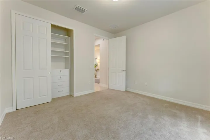 Unfurnished bedroom with a closet and light carpet
