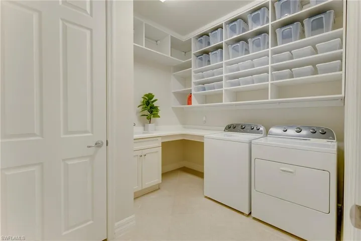 Washroom featuring washing machine and clothes dryer and light tile patterned flooring