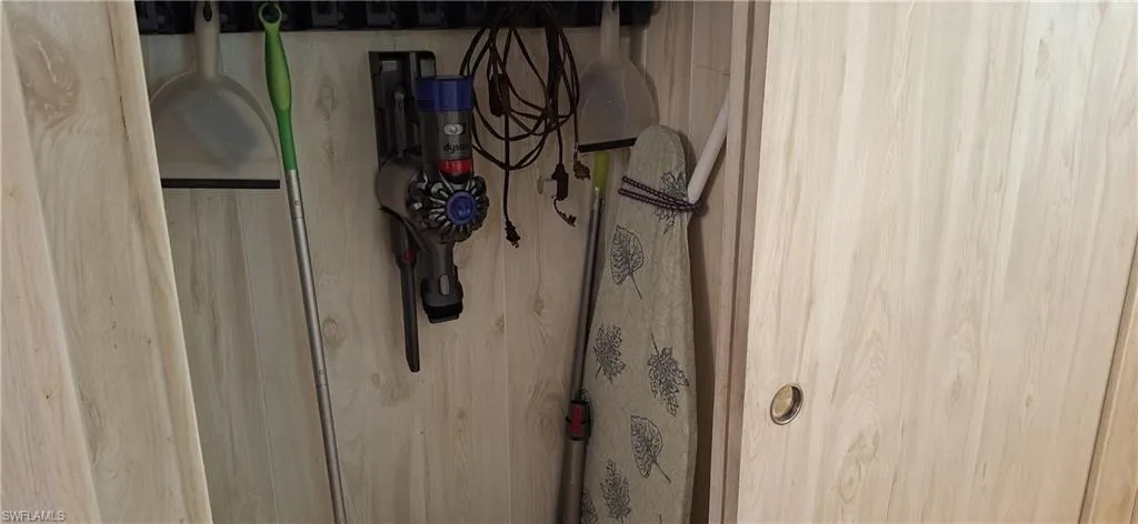Vacuum and ironing board in Hallway Closet
