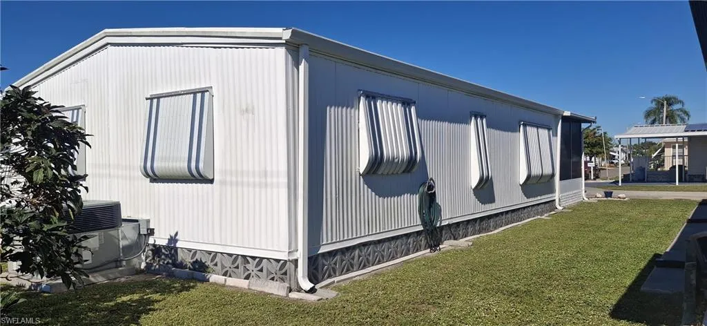 View of side of property featuring a central air condition unit and shutters