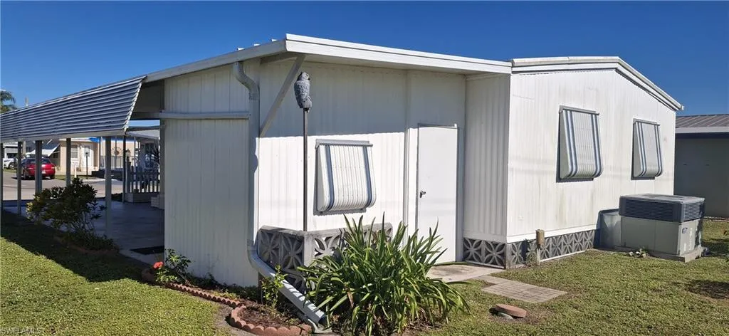 View of home's exterior with a rear door to storage shed