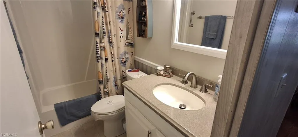 Guest bathroom with shower / bath combo, toilet, and vanity