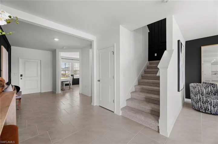 Tiled flooring, interior doors, carpeted stairway, staircase newel post, and recessed lighting