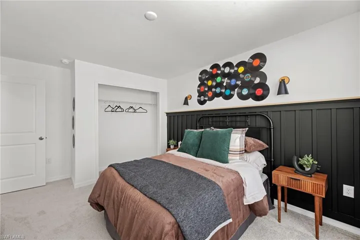 Built-in closet, white two-panel door, wall-mounted sconces, and board and batten wall detailing