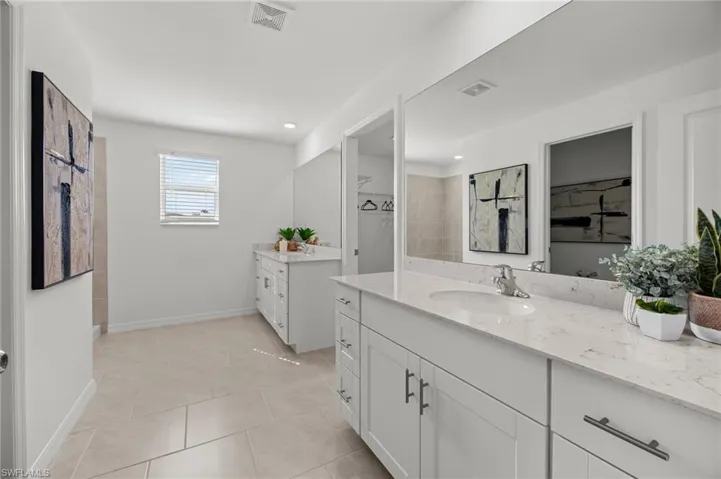 Dual vanity with white cabinetry, light-toned countertops, and integrated sinks