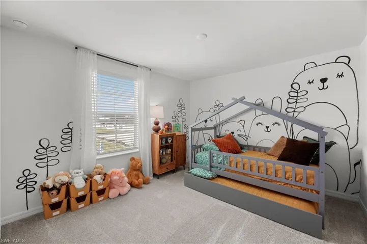 Bright room featuring carpeted flooring and an exterior window with blinds and sheer curtains