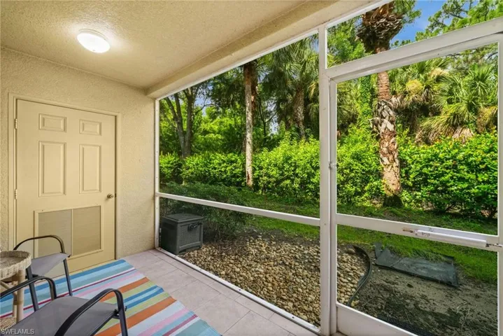 Screened patio featuring tile flooring and a textured wall finish