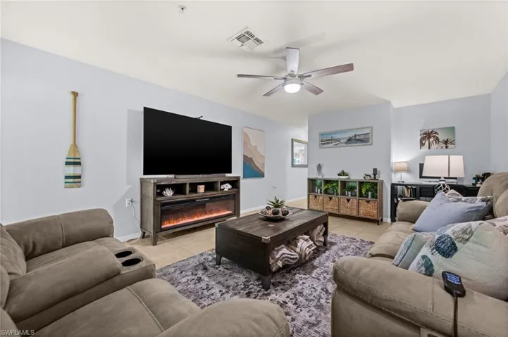 Open concept living area featuring light-colored walls and tile flooring
