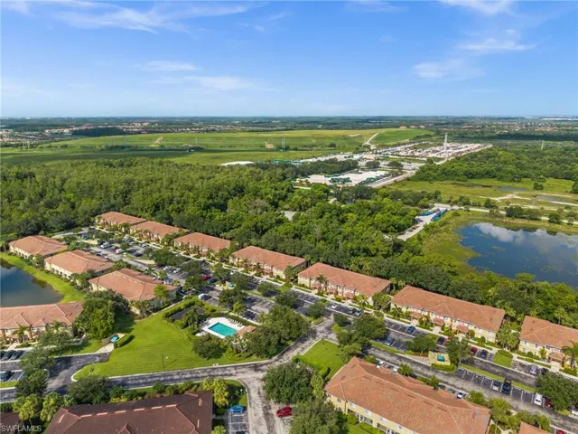 Aerial perspective showcasing multiple residential buildings with terracotta-style tile roofs, surrounded by lush green landscaping