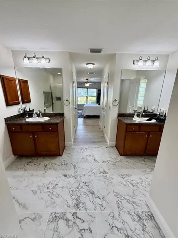 Full bath featuring a sink, marble finish floor, and ensuite bath