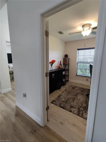 Corridor featuring light wood-style flooring and an office area