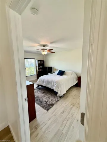 Bedroom featuring baseboards, wood finished floors, and a ceiling fan