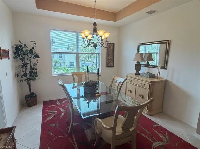 Dining area featuring a coffered ceiling, tiled flooring, and a multi-pane window
