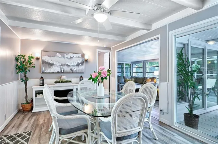 Dining room featuring beamed ceiling, ceiling fan, light hardwood / wood-style floors, and a textured ceiling