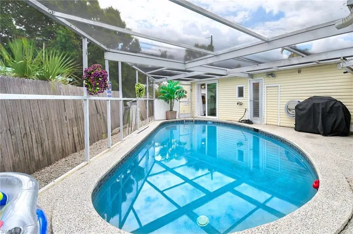 View of swimming pool featuring glass enclosure
