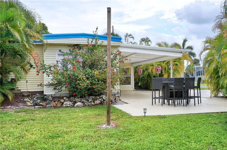 Rear view of property featuring a lawn and a patio