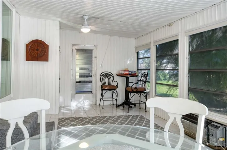 Dining space with ceiling fan and wood walls