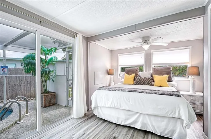 Bedroom featuring a textured ceiling, access to exterior, ceiling fan, and light wood-type flooring