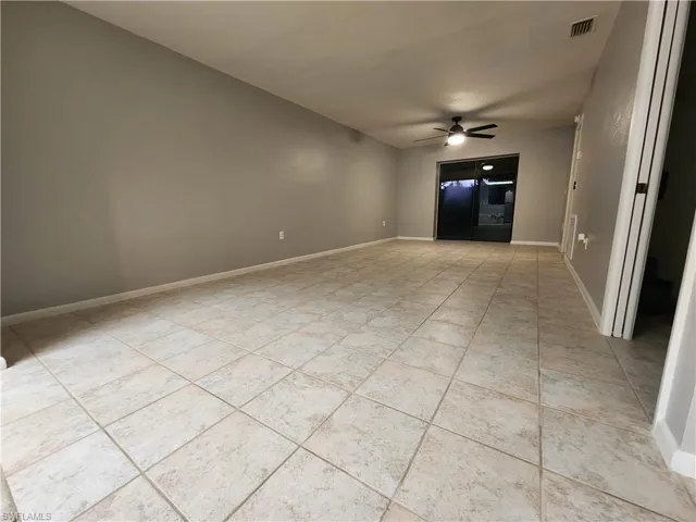 Unfurnished living room with light tile patterned flooring and ceiling fan