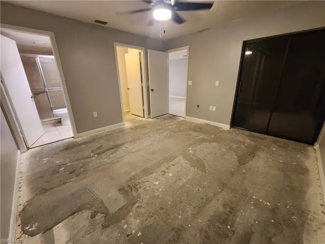 Unfurnished bedroom with ensuite bath and ceiling fan