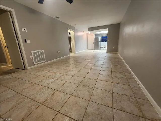 Unfurnished room featuring light tile patterned flooring and ceiling fan