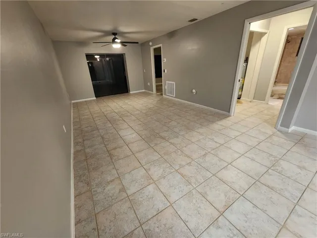 Unfurnished living room featuring ceiling fan and light tile patterned floors