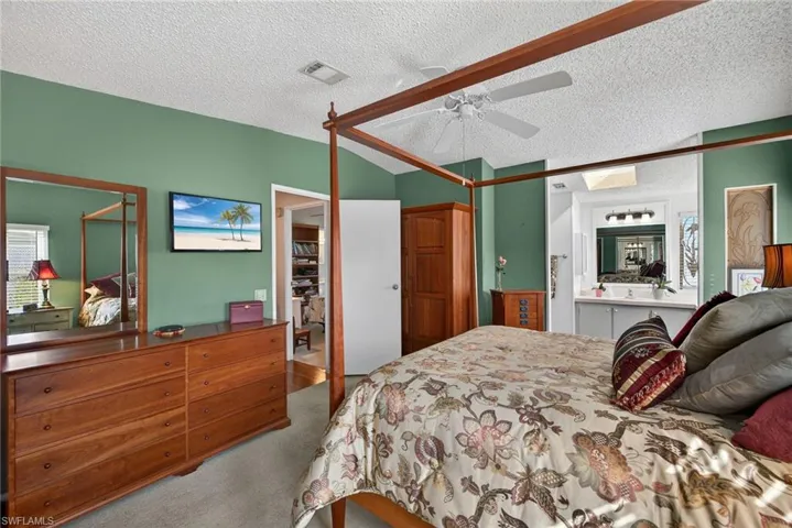 Bedroom featuring light carpet, a textured ceiling, ceiling fan, and a skylight
