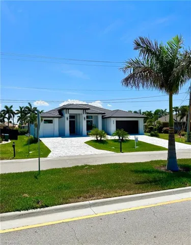 View of front of house with a garage and a front lawn