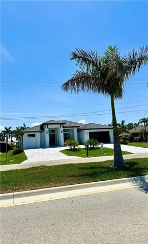 View of front of house with a front yard and a garage