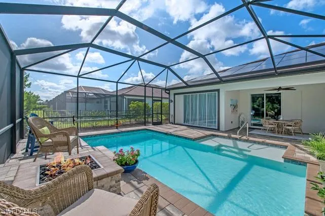 Screened enclosure surrounding a custom swimming pool with integrated sun shelf