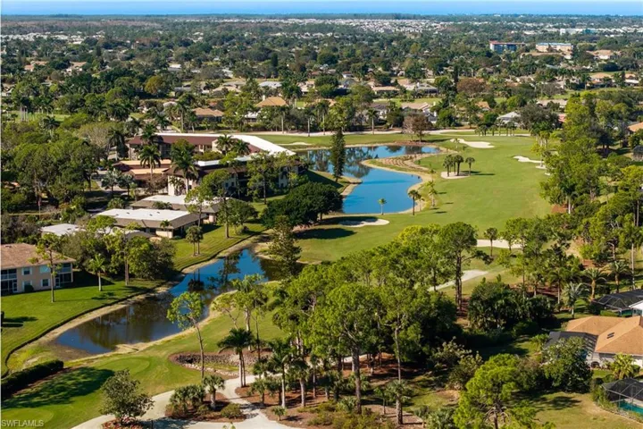 View of property location featuring a large body of water, a golf club, and nearby suburban area